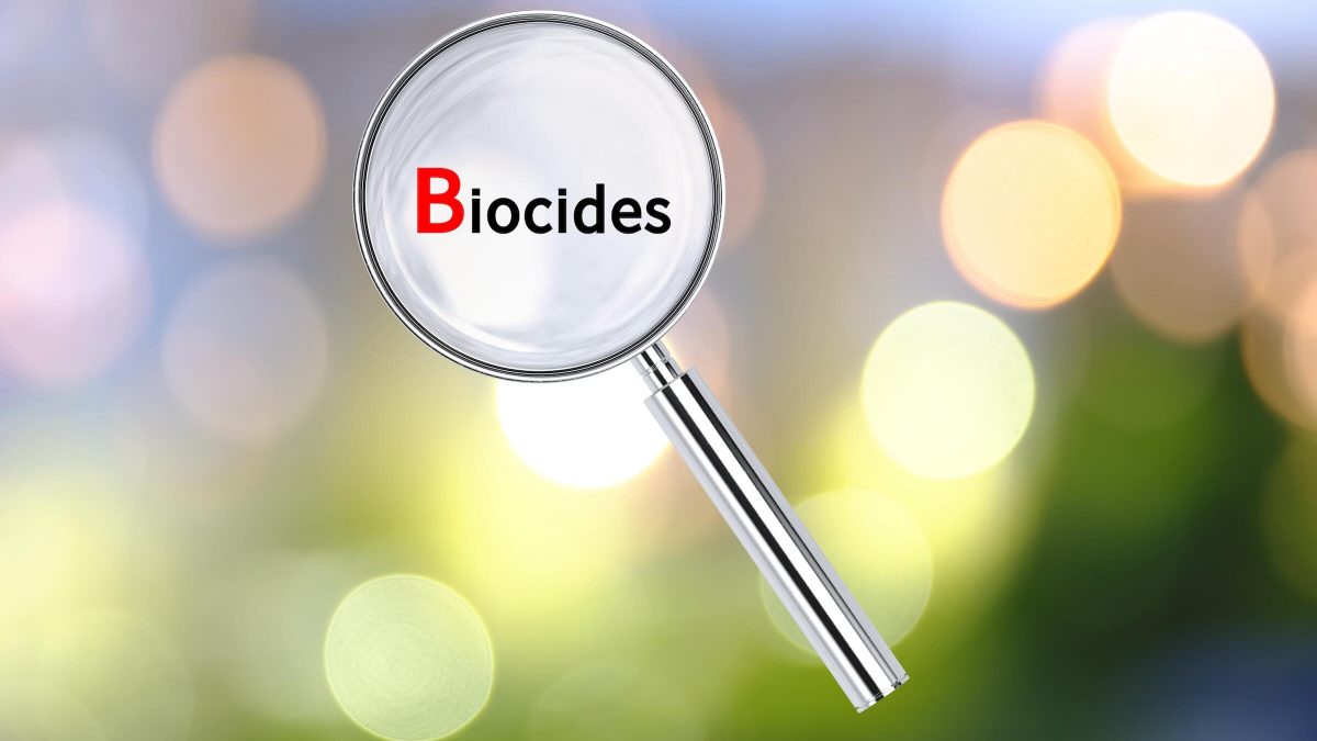 Soczewka powiększająca na tle z tekstem Biocides